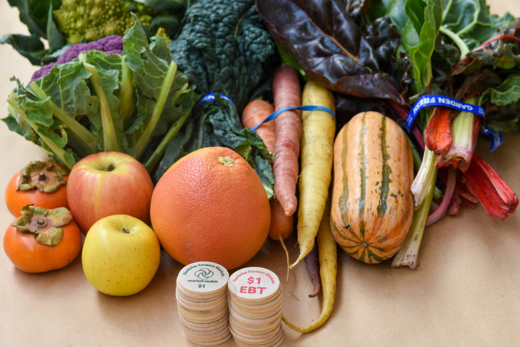 A display of produce from the farmers market with CalFresh (EBT) and Market Match tokens